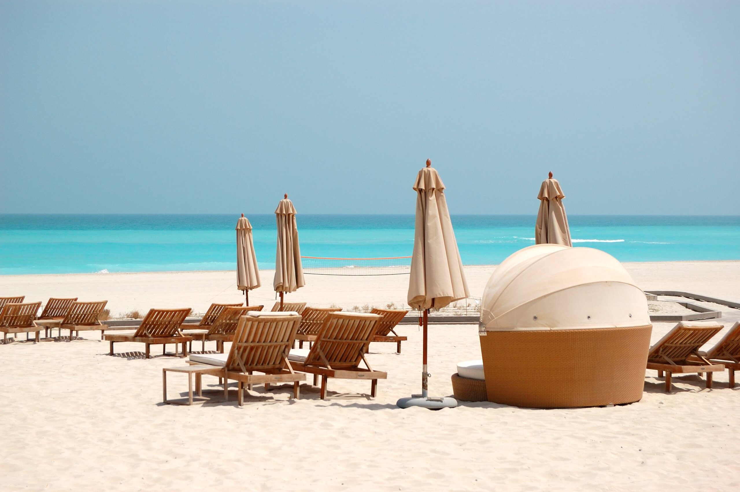 Chaises longues et parasols sur la plage de Saadiyat à Abu Dhabi face à la mer turquoise.