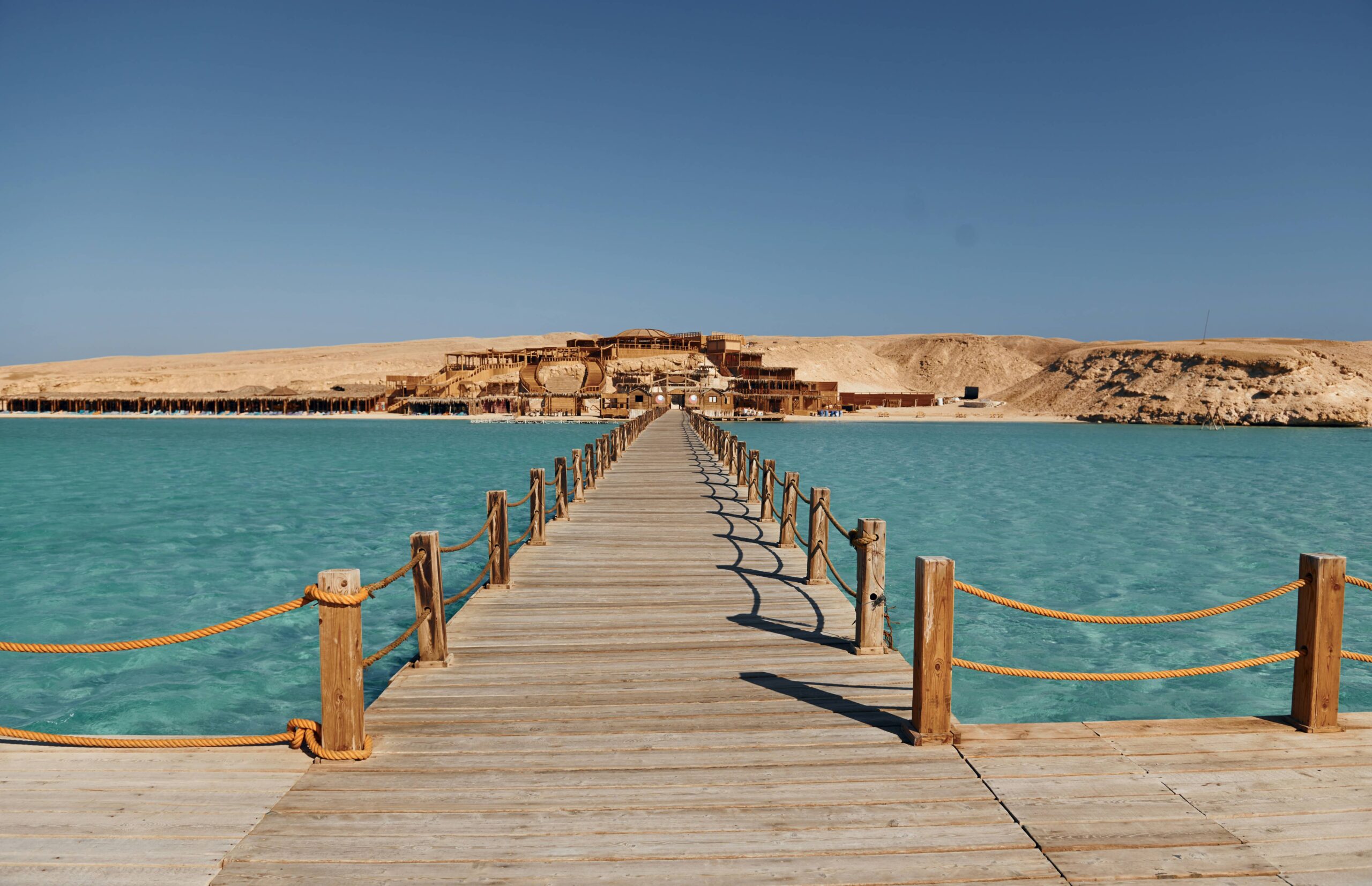 Pont en bois sur la mer Rouge menant à un resort de luxe en Égypte.