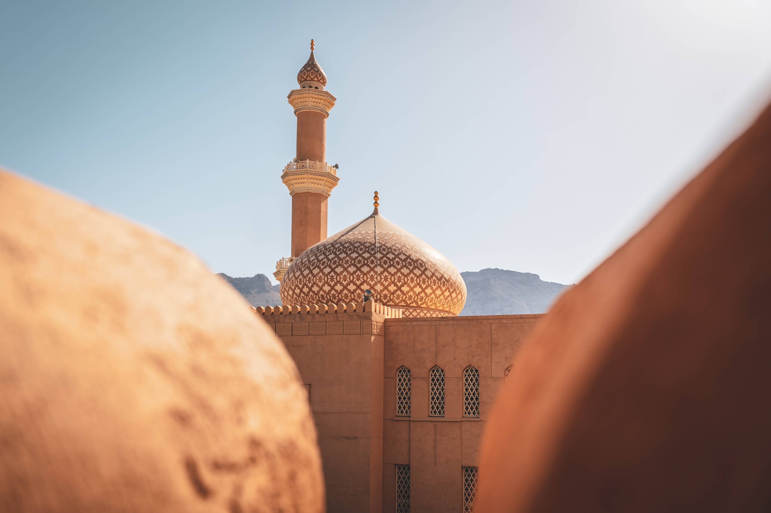 Fort de Nizwa et montagnes en arrière plan en Oman